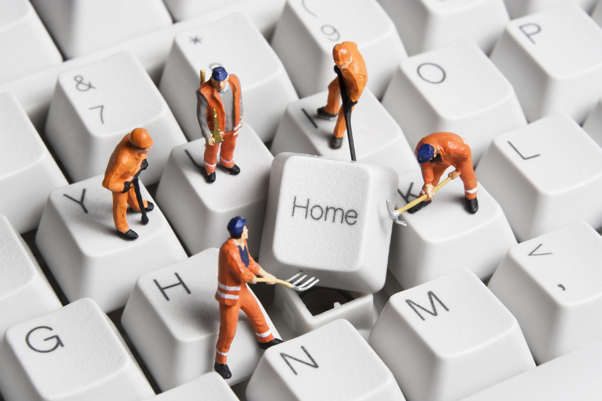 photo illustration of miniature workers on keyboard erecting the home key on a keyboard